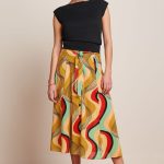 Falda Midi Judy de King Louie, corte acampanado con lazo decorativo en la parte delantera, botones frontales y confeccionada en algodón BCI.